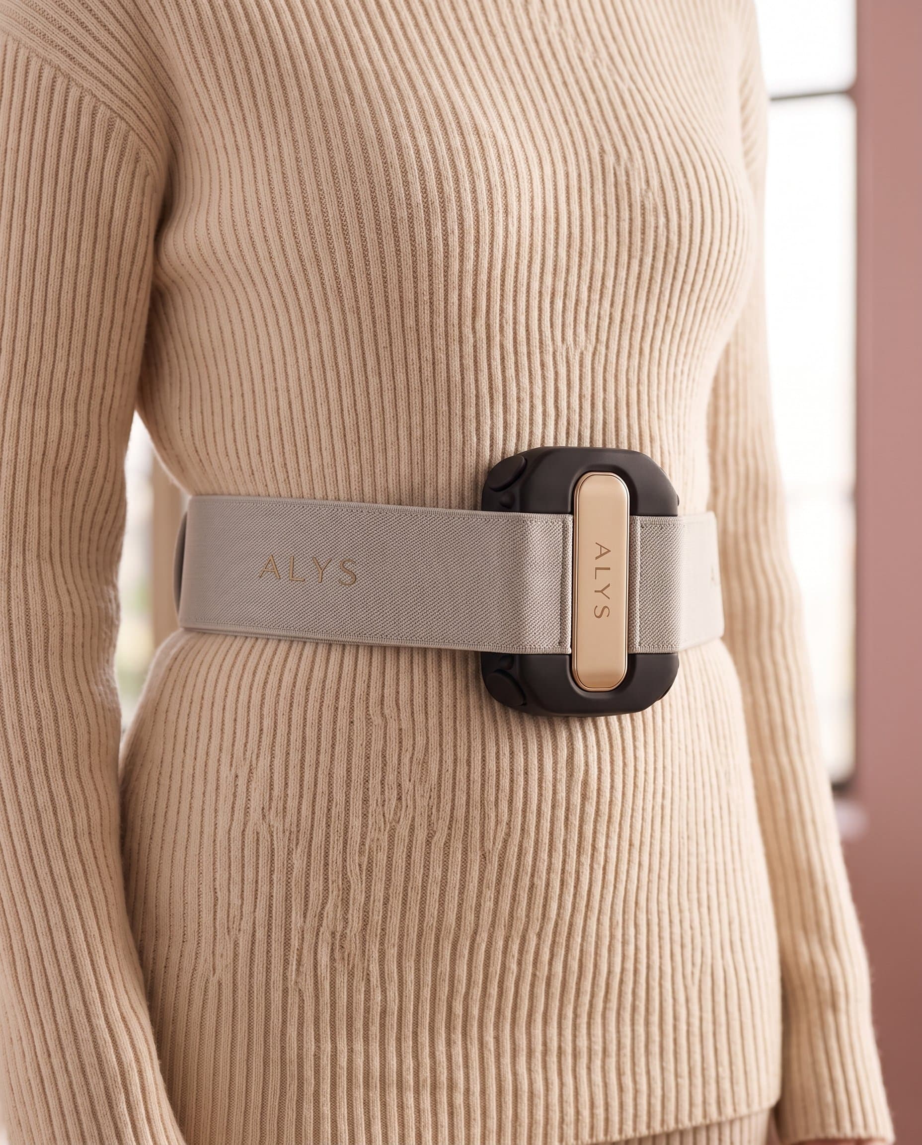 ALYS CORE worn over neutral knitwear, detail crop