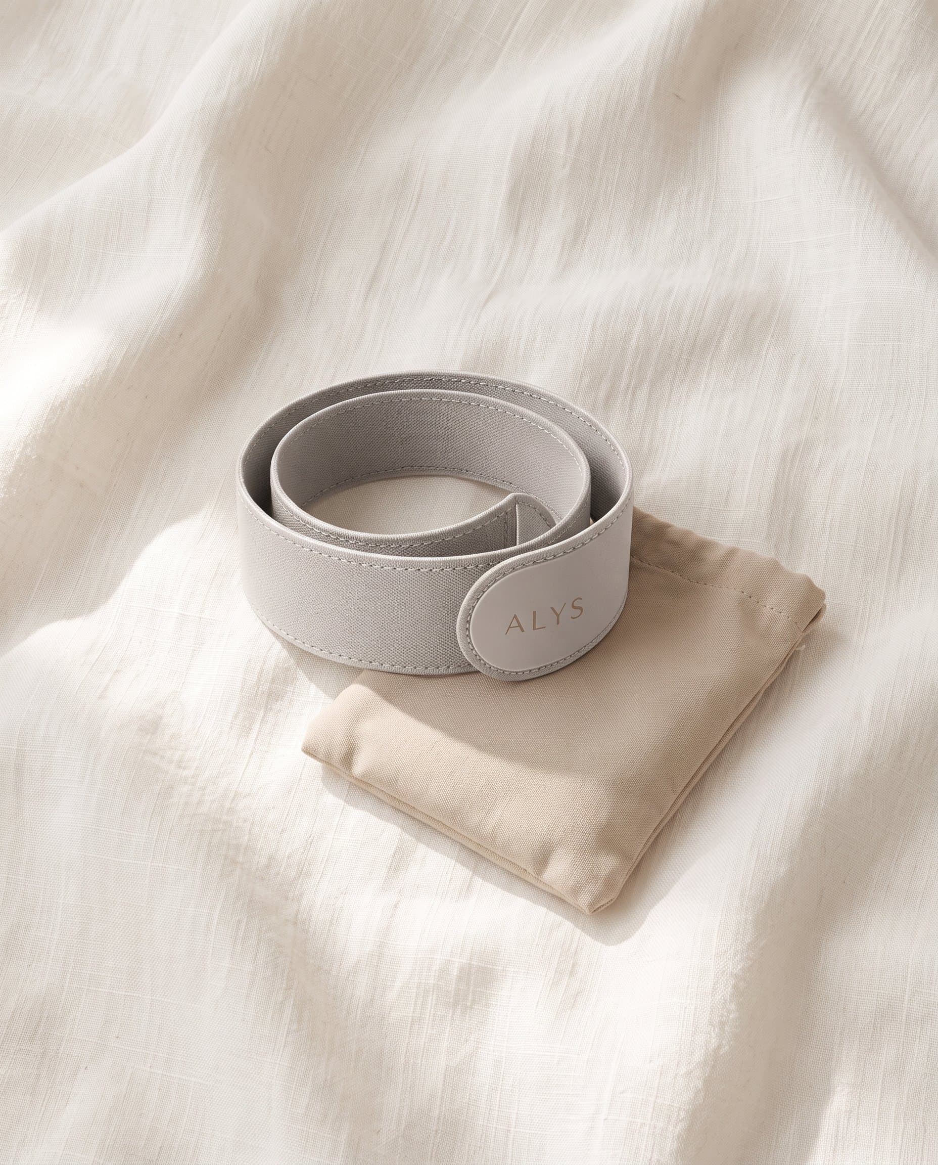 ALYS CORE flat lay with travel pouch on warm white linen